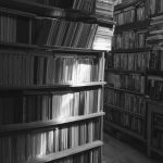 Old cozy library. Game of light and shadow on shelves with books in the library. Background Library.